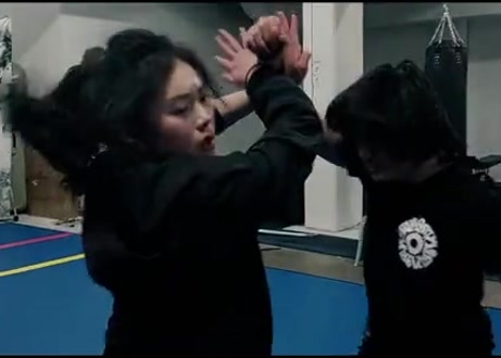 Anna in a close-up from a choreographed combat practice